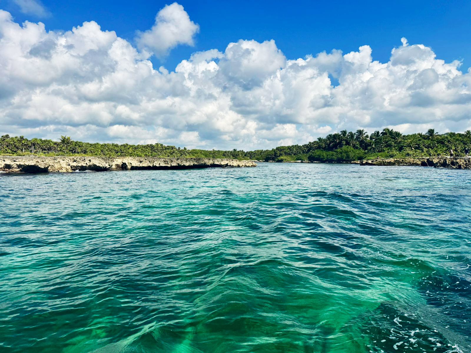 Emerald water flowing toward an inlet between two limestone shores